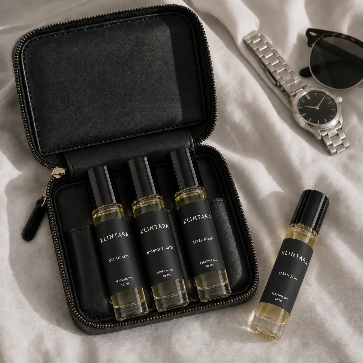 Black-label Klintara perfume-oil rollers in a compact black travel pouch